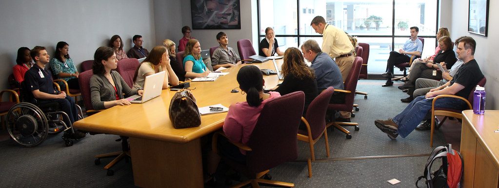 Equipe reunida em uma sala de reuniões discutindo e avaliando resultados, representando a medição do impacto de iniciativas de saúde mental no trabalho.