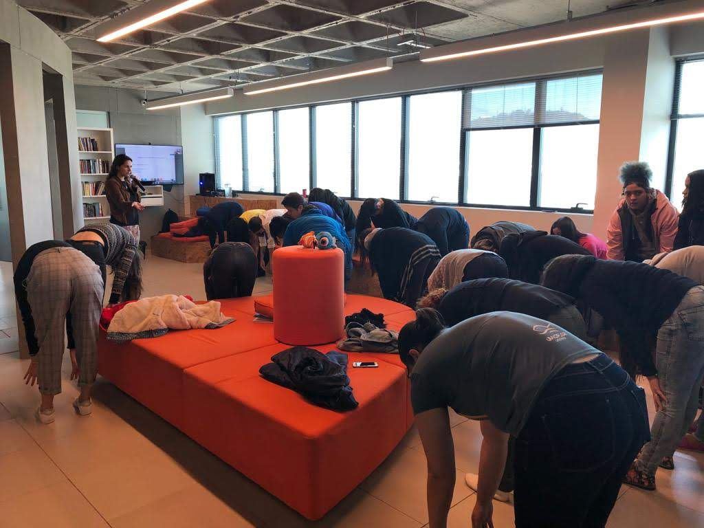 Dani Pinotti ministrando palestra corporativa sobre bem-estar e saúde mental para equipe em ambiente empresarial.