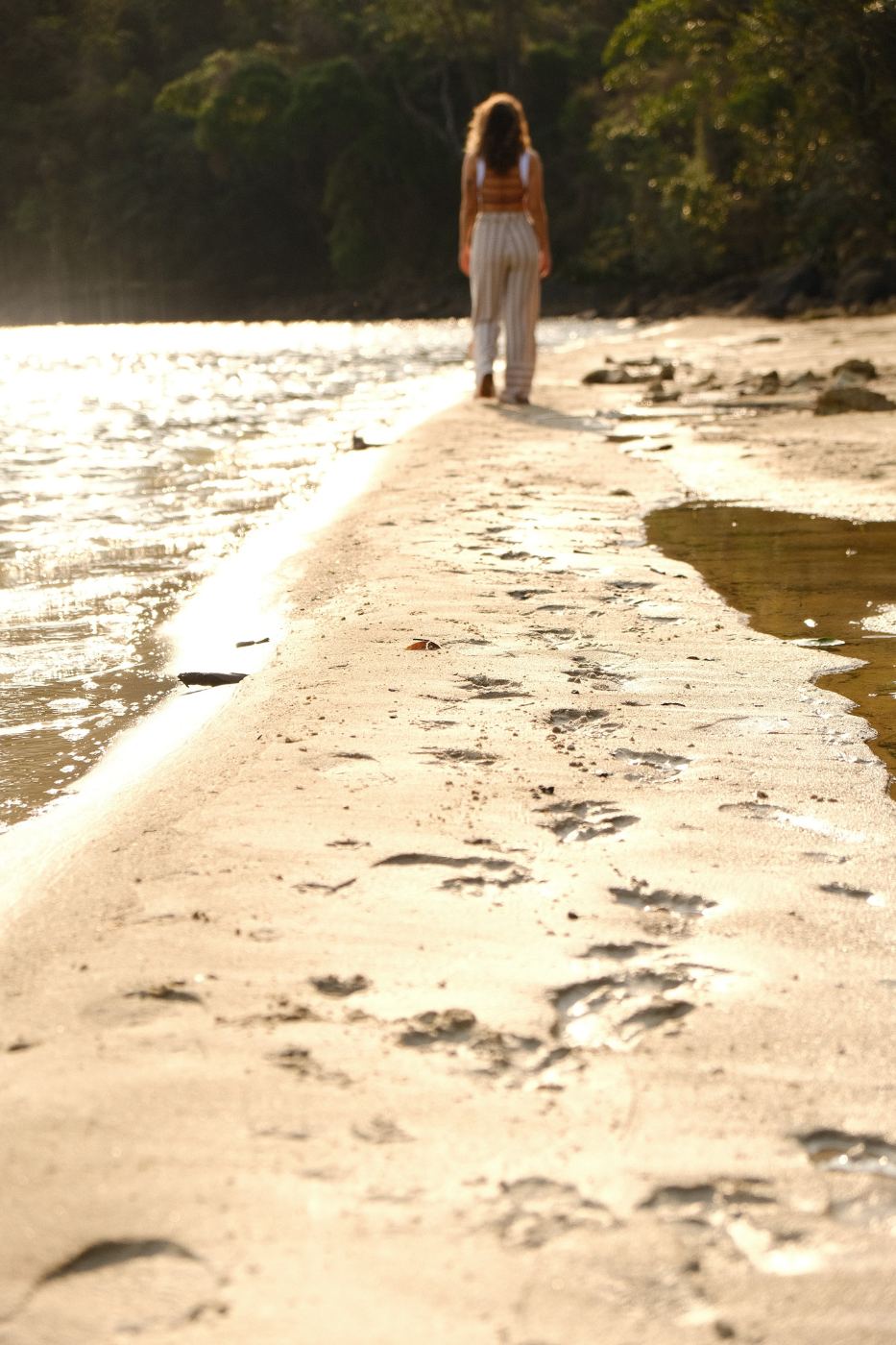 Caminhada consciente e leve na praia, representando uma prática de yoga acessível e respeitosa ao corpo.