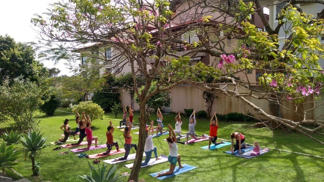 Prática de yoga suave ao ar livre, em ambiente acolhedor e tranquilo, cercado por natureza.