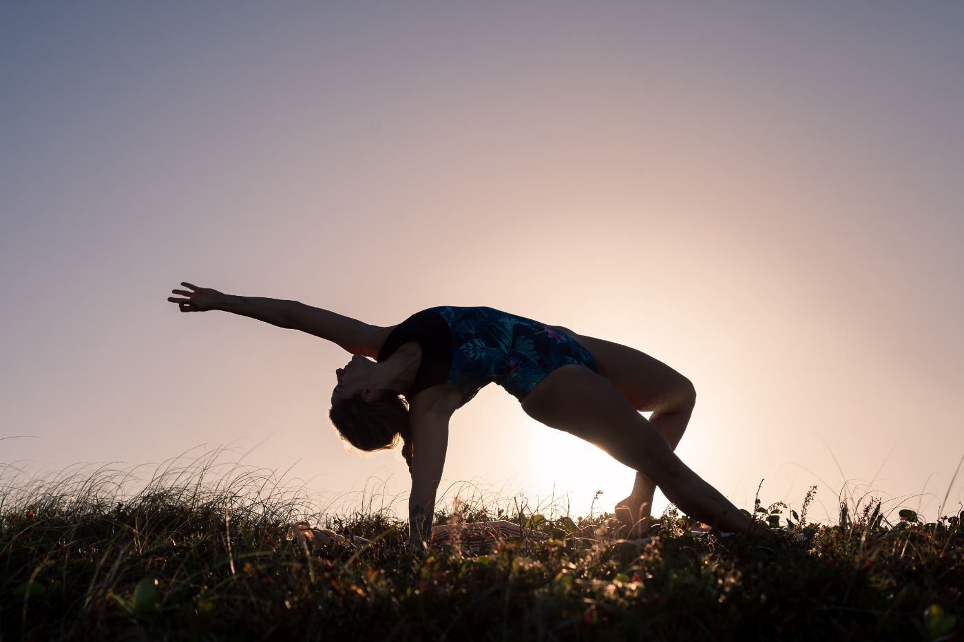 Dani Pinotti praticando uma postura de yoga individual ao ar livre, em momento de dedicação pessoal à prática.